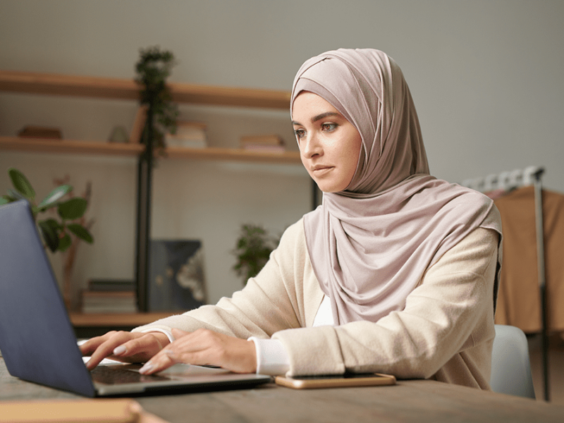 horizontal-portrait-attractive-middle-eastern-woman-wearing-hijab-spending-time-modern-office-room-working-laptop